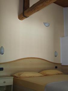 um quarto com uma cama e uma cabeceira em madeira em Agritur Fior di Melo em Nanno