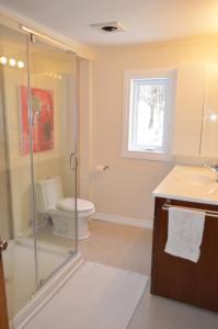 a bathroom with a toilet and a glass shower at Lakeside Cottage in Wentworth