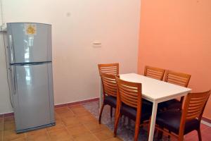 Un comedor con una mesa y un refrigerador. en Homestay Kota Bharu, Telipot, en Kota Bharu 2 fotos más