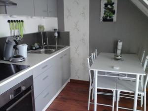 a kitchen with a sink and a table with chairs at Chez Marcelline in Amécourt