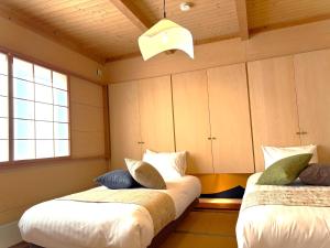 a room with two beds and a window at Villa和心 in Asahikawa
