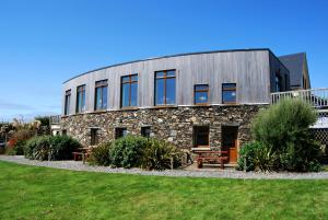 a stone building with windows and a lawn at Dolphin Hotel in Inishbofin