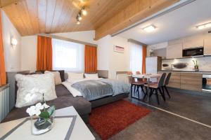 sypialnia z łóżkiem i stołem oraz kuchnią w obiekcie Appartements Schneezauber w mieście Lermoos