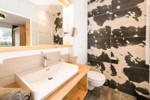 a bathroom with a white sink and a map of the world on the wall at APART Forellenhof in Flachau