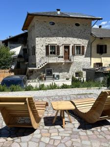 two chairs and a table in front of a house at Palazzo Tamanini in Calceranica al Lago