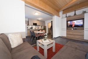 salon z kanapą, stołem i telewizorem w obiekcie Appartements Schneezauber w mieście Lermoos