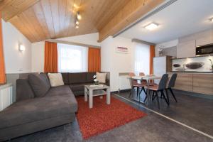 salon z kanapą i stołem w obiekcie Appartements Schneezauber w mieście Lermoos +37 zdjęć
