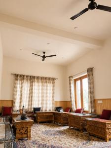 a living room with couches and a ceiling fan at ཨོཾ Homestay in Lāmayūrū