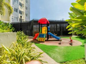 a playground with a slide in a yard at Staycation Hub in Mandaue City