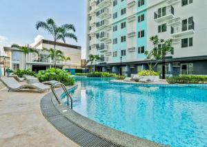 a large swimming pool with chairs and buildings at Staycation Hub in Mandaue City
