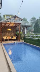 a large swimming pool in a yard with a house at 5BR Villa with Private Pool Lembang in Bandung