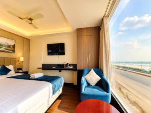 a hotel room with a bed and a window with the beach at Hotel Eastern Dham Puri in Puri +20 photos