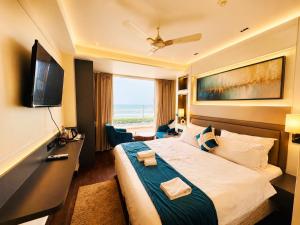 a hotel room with a bed and a television at Hotel Eastern Dham Puri in Puri