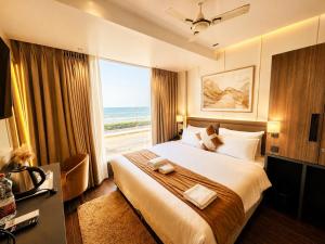 a bedroom with a large bed with a large window at Hotel Eastern Dham Puri in Puri