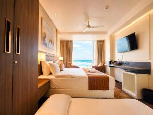 a hotel room with two beds and a television at Hotel Eastern Dham Puri in Puri