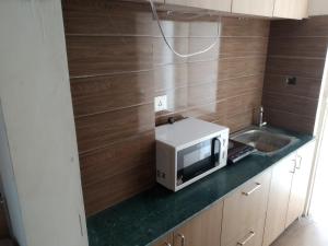 a microwave sitting on a counter in a kitchen at The kanha Luxury Suites in Greater Noida
