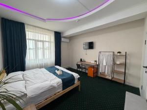 a bedroom with a bed and a tv on the ceiling at Саратан отель in Osh