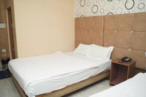 a bedroom with two beds and a phone on a night stand at Hotel Nova in Itahari +8 photos