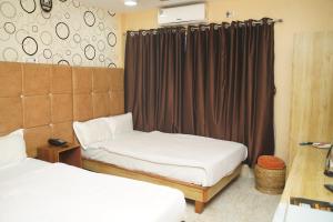 a small room with two beds and a curtain at Hotel Nova in Itahari