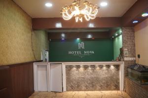 a lobby of a hotel room with a chandelier at Hotel Nova in Itahari