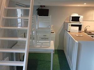 a kitchen with white shelving and a microwave oven at Camping des Cèpes in La Salvetat