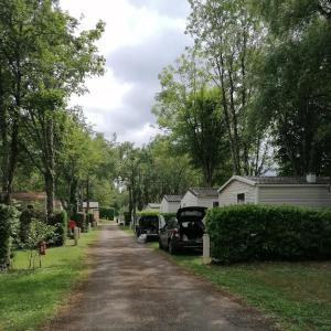 a house with cars parked on the side of a driveway at Camping des Cèpes in La Salvetat +1 photo