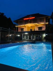 a swimming pool in front of a building at night at Athirappilly Ambady Resort in Athirappilly