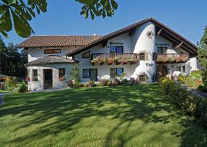 ein großes weißes Haus mit einem großen Hof in der Unterkunft Pension Bergstub`n in Saldenburg