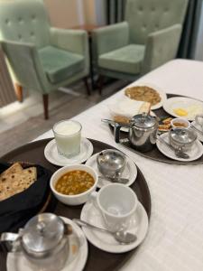 a table with a tray of food on a table at Shelton Boulevard Hotel Lahore in Lahore