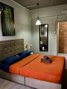 a bedroom with a large bed and a mirror at BRICKS Cameron Hostel in Tanah Rata