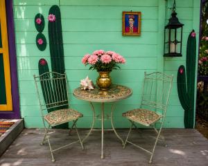 a table with a vase of flowers sitting between two chairs at Mammaloe in Oranjestad +156 photos