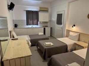 a small room with two beds and a kitchen at Villa Markos in Perissa