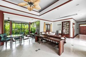 a living room with a ping pong table and a ceiling fan at The Baan Bua Elefant Villa in Rawai Beach
