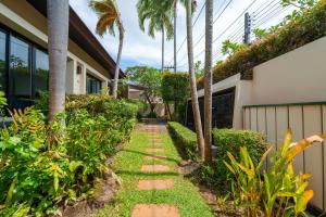 a garden path leading to a house with palm trees at The Baan Bua Elefant Villa in Rawai Beach