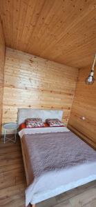 a bed in a wooden room with a wooden ceiling at Bobokvati Eco Twins in Dagva +46 photos
