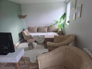 a living room with a couch and two chairs at Petite maison sympathique in Auvers