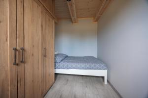 a small bedroom with a bed and wooden cabinets at Agroturystyka Oliweczka 24 in Potok Wielki