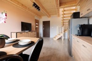 a kitchen and dining room with a table and a refrigerator at Agroturystyka Oliweczka 24 in Potok Wielki +3 photos