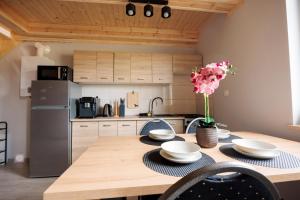 a kitchen with a table with plates and flowers on it at Agroturystyka Oliweczka 24 in Potok Wielki