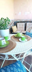 a table with green cups and saucers on it at Gina&Gian Guest House in Olbia