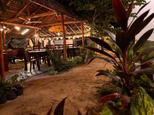 a restaurant with a table and people in the background at Blue Wings Arugam Bay in Arugam Bay