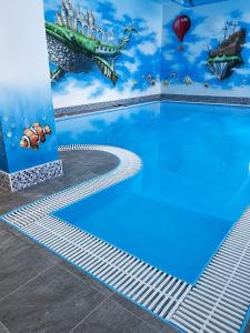 a swimming pool with a mural of a pirate ship at Pasja Dom Wypoczynkowy Świeradów - Zdrój w górach in Świeradów-Zdrój