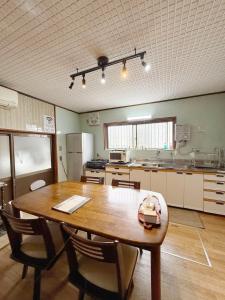 a large kitchen with a wooden table and chairs at fully in Otsu