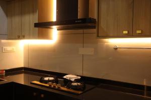 a kitchen with two pans on a stove top at Science House Lux Inn in Kadayirippu +4 photos