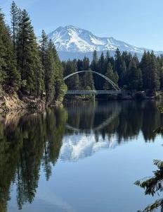 a bridge over a lake with a mountain in the background at Anissa Shasta Hostel in Weed