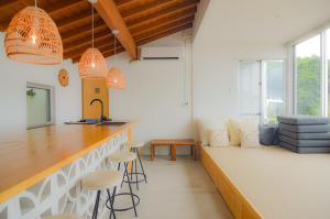a kitchen with a bar and stools in a room at Hummocks in Sesoko