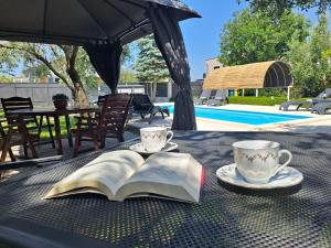 an open book on a table with two cups of coffee at Villa Grace Felice in Fažana