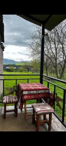 a picnic table and two benches on a porch at Tsatʼer Guest House in Tsatʼer