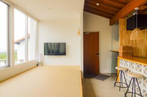 a living room with a large window and a tv at Hummocks in Sesoko