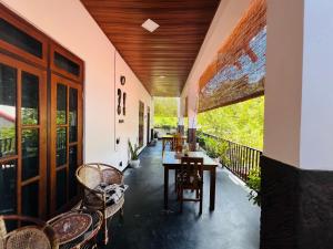 a porch with chairs and a table on a balcony at Ceylonima Home Stay in Anuradhapura